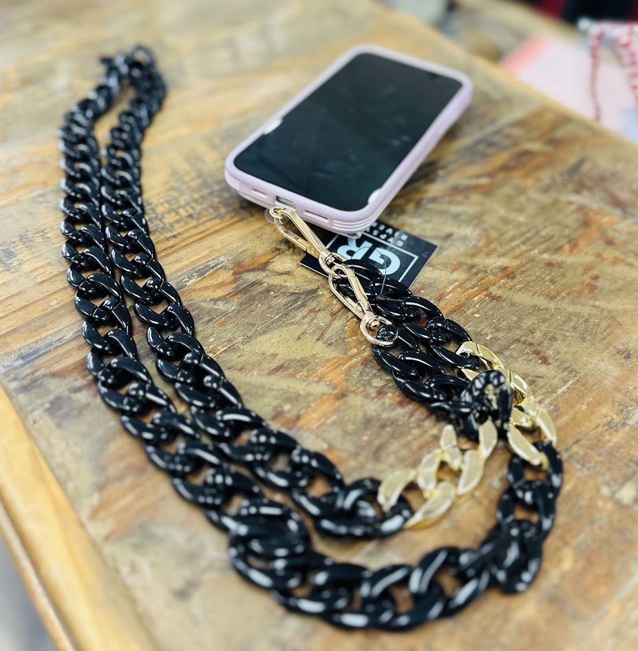 Black chain phone strap with gold clasp on a wooden surface