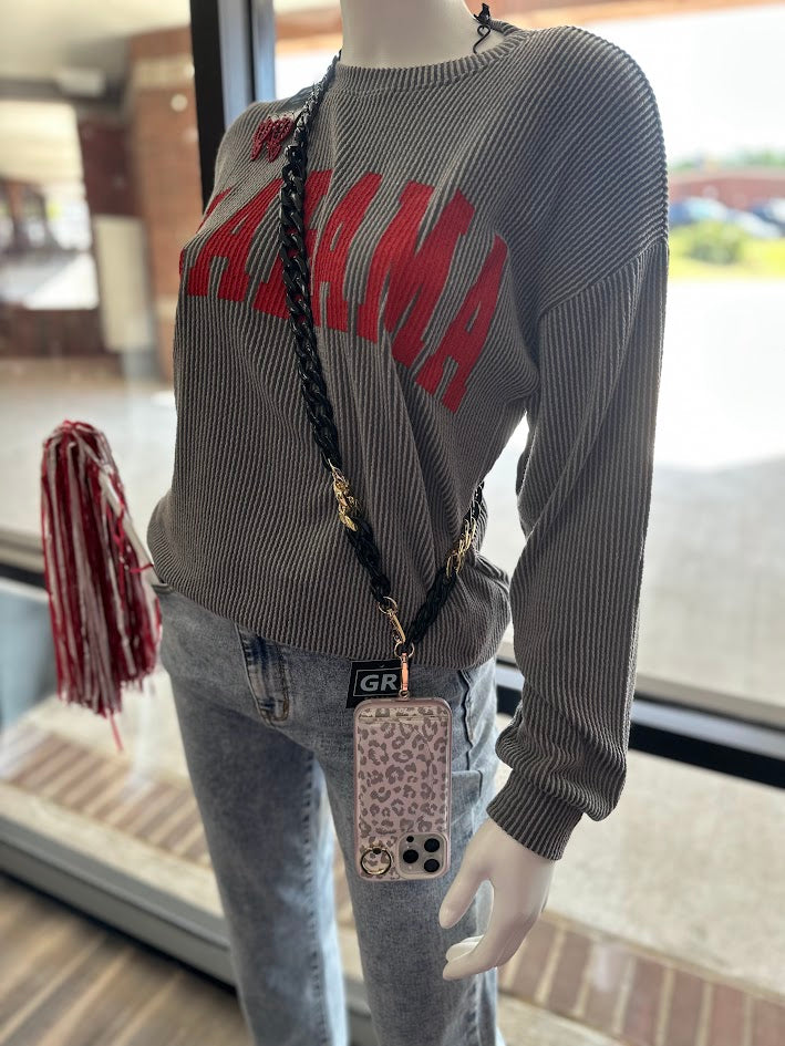 Mannequin wearing a gray sweater with red text and light blue jeans, holding a phone case.