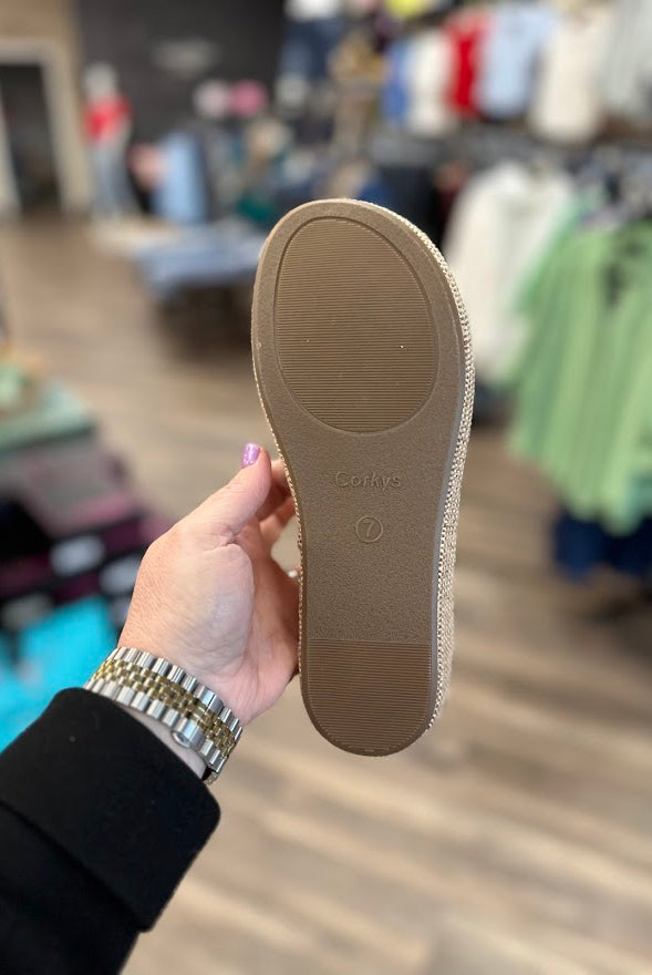 Person holding a brown shoe sole with 'Celine' branding in a store setting.