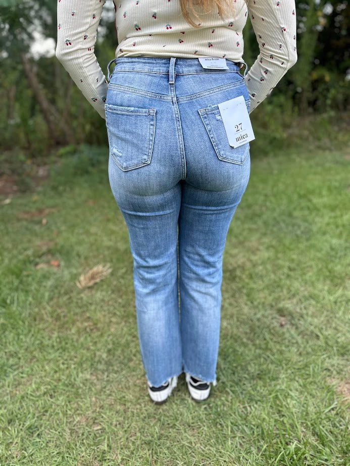 Person wearing blue jeans with a visible brand label outdoors on grass