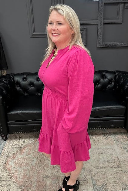 Woman in a pink dress standing in a store with Christmas decorations and 'Gypsy River Apparel' sign.