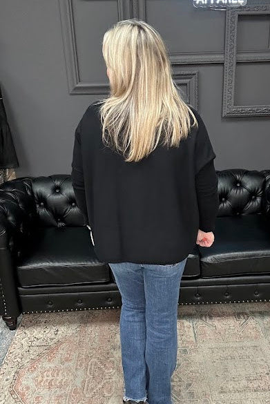 Person standing in front of a black leather couch with a Christmas tree and 'Gypsy River Apparel' sign in the background.