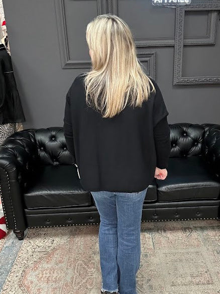 Person standing in front of a black leather couch with a Christmas tree and 'Gypsy River Apparel' sign in the background.