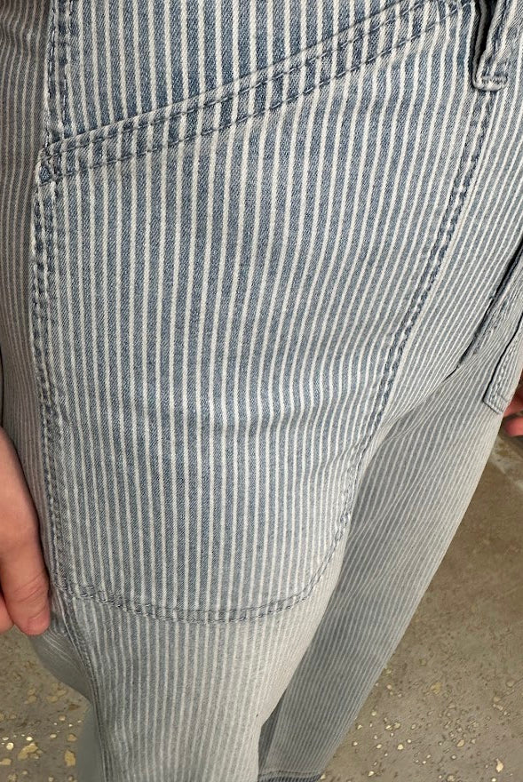 Close-up of gray and white striped pants on a concrete surface