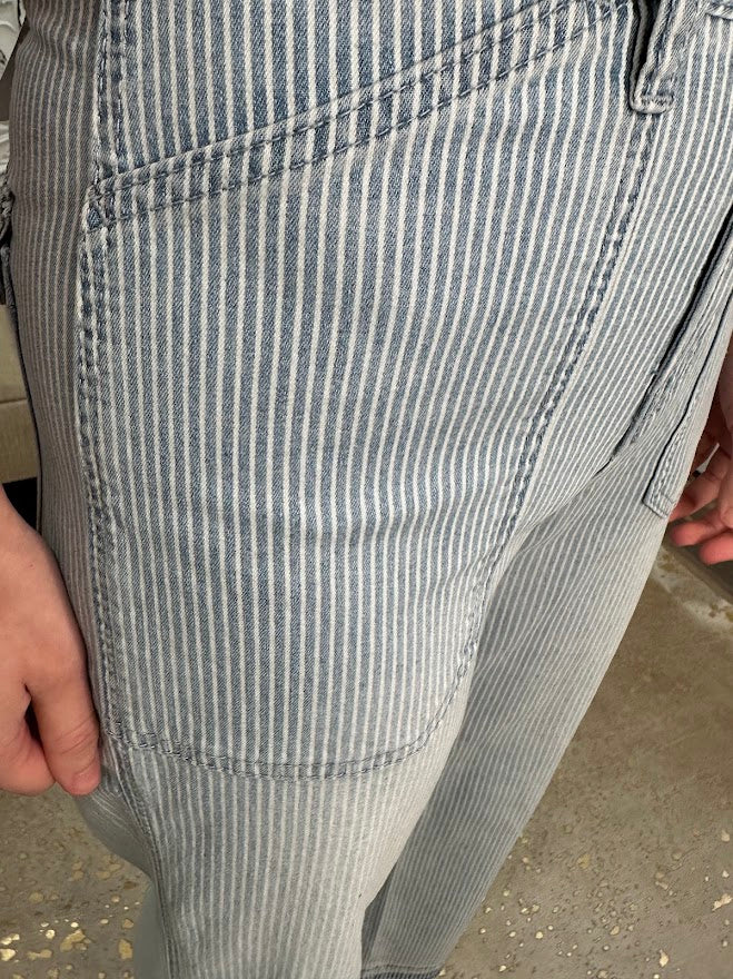 Close-up of gray and white striped pants on a concrete surface