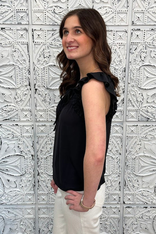 Liverpool black sleeveless blouse with ruffle trim and tie front neckline on model