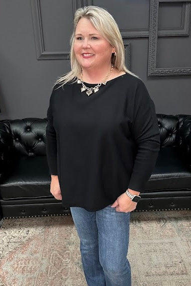 Woman standing in a store with a Christmas tree and 'Gypsy River Apparel' sign.