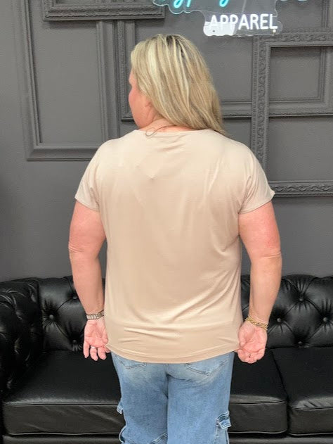 Person standing in a room with a black leather couch and gray walls.