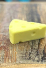 Yellow cheese wedge on a wooden surface