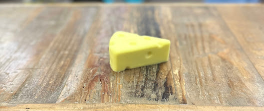 Yellow cheese wedge on a wooden surface