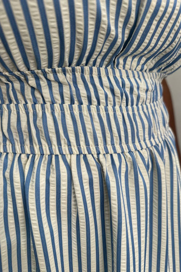Close-up of a blue and white striped dress with a belt.