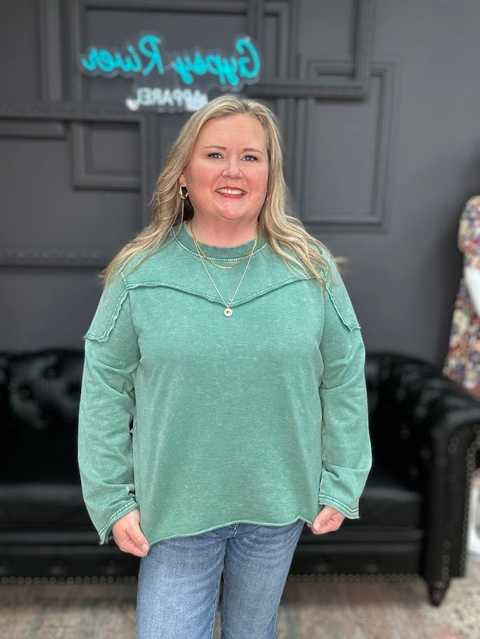 Woman wearing green washed Easel long sleeve top with front yoke seam detail and casual fit.