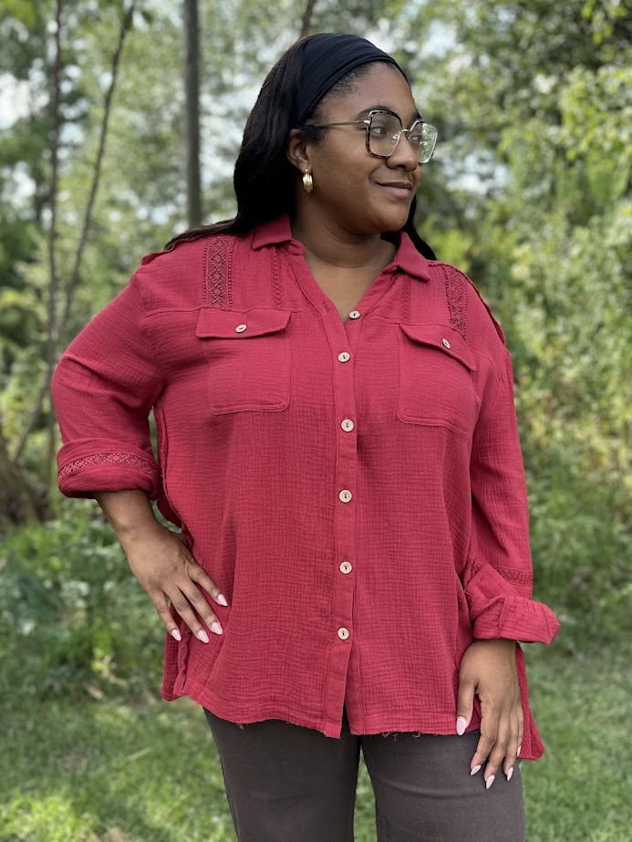 Woman wearing a red shirt with a blurred green background