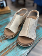 Pair of beige open-toe sandals on a wooden surface