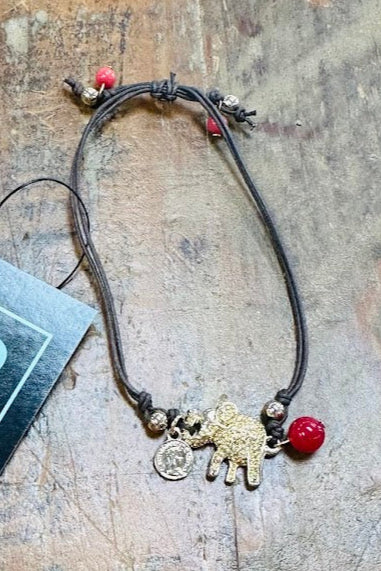 Bracelet with charms on a wooden surface, featuring 'Gypsy River' brand tag.