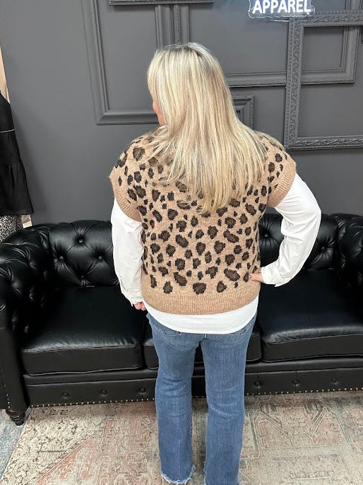 Person wearing a leopard print vest in front of a black couch with 'Gypsy River Apparel' sign.
