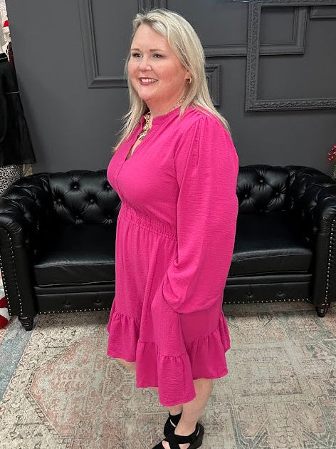 Woman in a pink dress standing in a store with Christmas decorations and 'Gypsy River Apparel' sign.