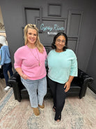 Two women standing in a room with a 'Gypsy River Apparel' sign in the background.