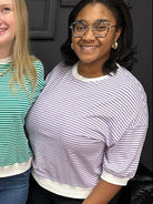 Three women posing together in a store setting with a sign in the background.