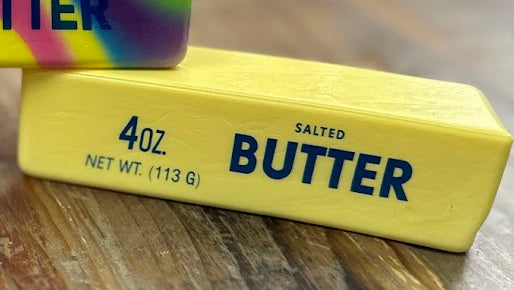 Three colorful butter bars on a wooden surface with a blurred background