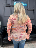Person wearing a patterned shirt with a black leather chair and gray wall in the background