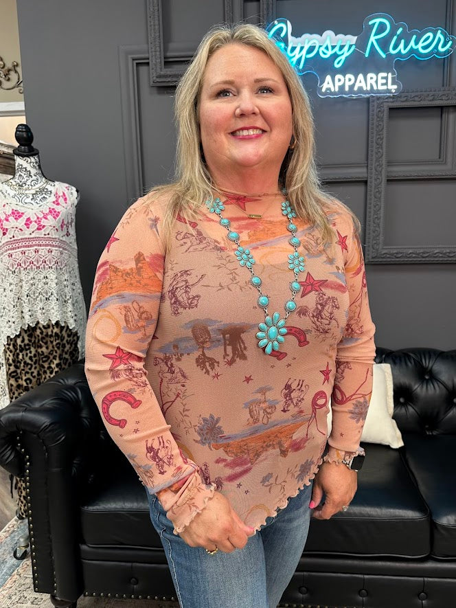 Woman wearing a patterned shirt with a necklace in front of a store interior.