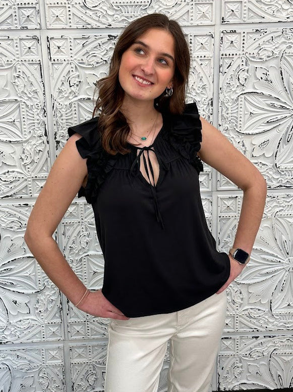 Liverpool black sleeveless blouse with ruffle trim and tie front neckline on model