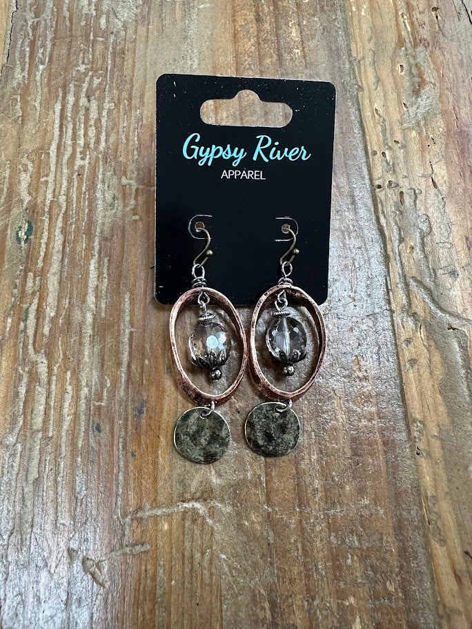 Copper-tone oval earrings with smoky crystal center and distressed metal drop. Lightweight, textured, and effortlessly bold.