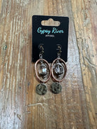 Copper-tone oval earrings with smoky crystal center and distressed metal drop. Lightweight, textured, and effortlessly bold.