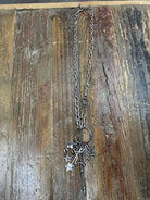 Chunky silver chain necklace with layered star charms and bold drop detail. Edgy, western-inspired statement style.