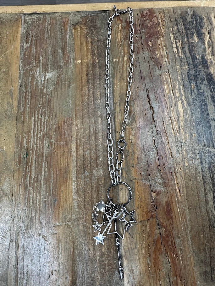 Chunky silver chain necklace with layered star charms and bold drop detail. Edgy, western-inspired statement style.
