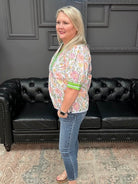 Woman standing in front of a black leather couch with a gray wall and text in the background