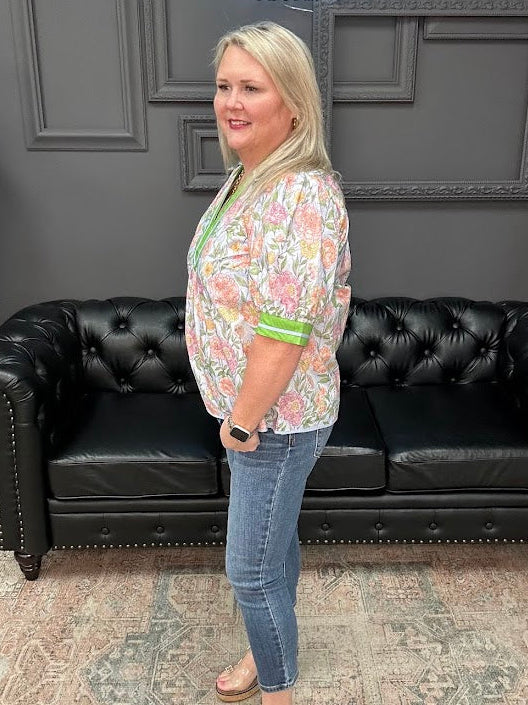 Woman standing in front of a black leather couch with a gray wall and text in the background