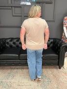 Person standing in a room with a black leather couch and gray walls.