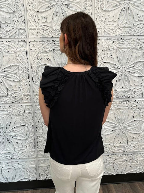 Liverpool black sleeveless blouse with ruffle trim and tie front neckline on model