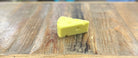 Yellow cheese wedge on a wooden surface