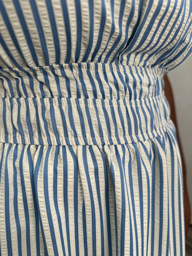 Close-up of a blue and white striped dress with a belt.