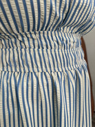 Close-up of a blue and white striped dress with a belt.