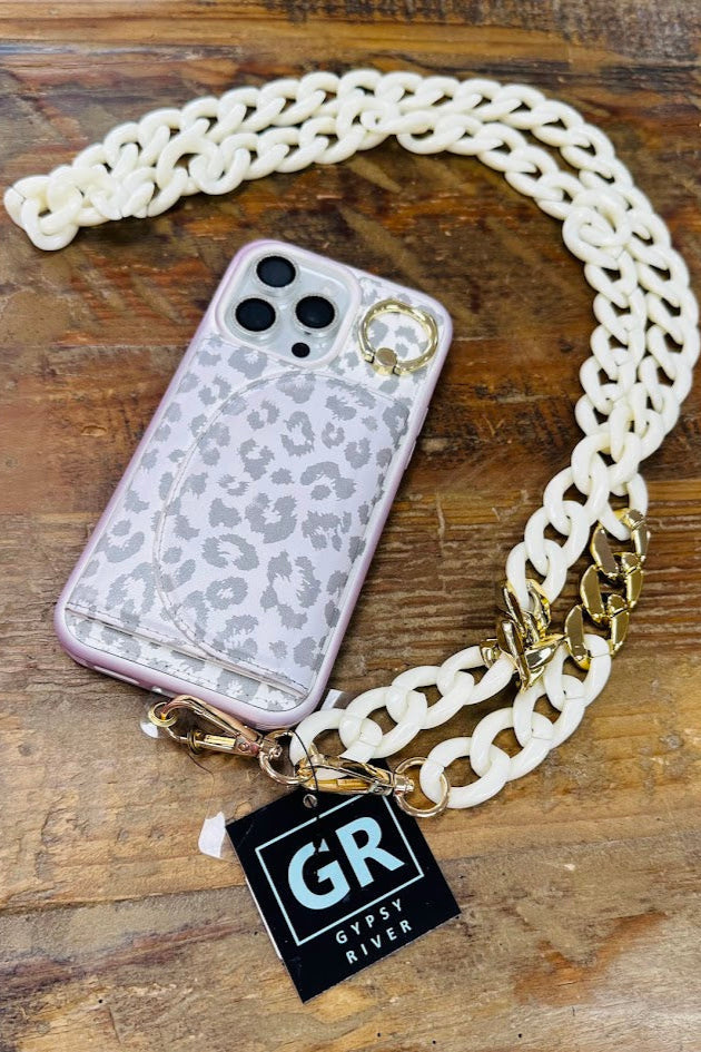 Phone case with chain strap and 'Gypsy River' tag on a wooden surface