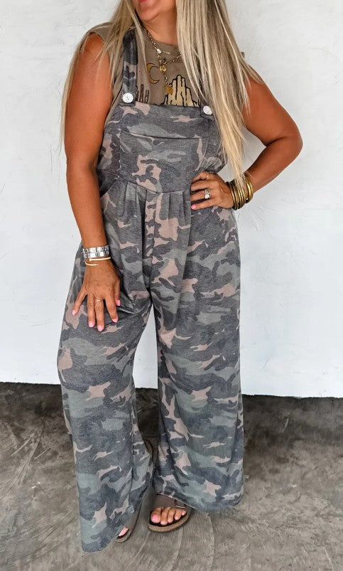 Person wearing camouflage overalls against a white background