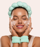Woman using a green face mask with a matching headband and gloves on a beige background