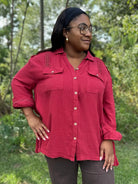Woman wearing a red shirt with a blurred green background